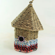 Bird nester in grass and sari fabric, house shape