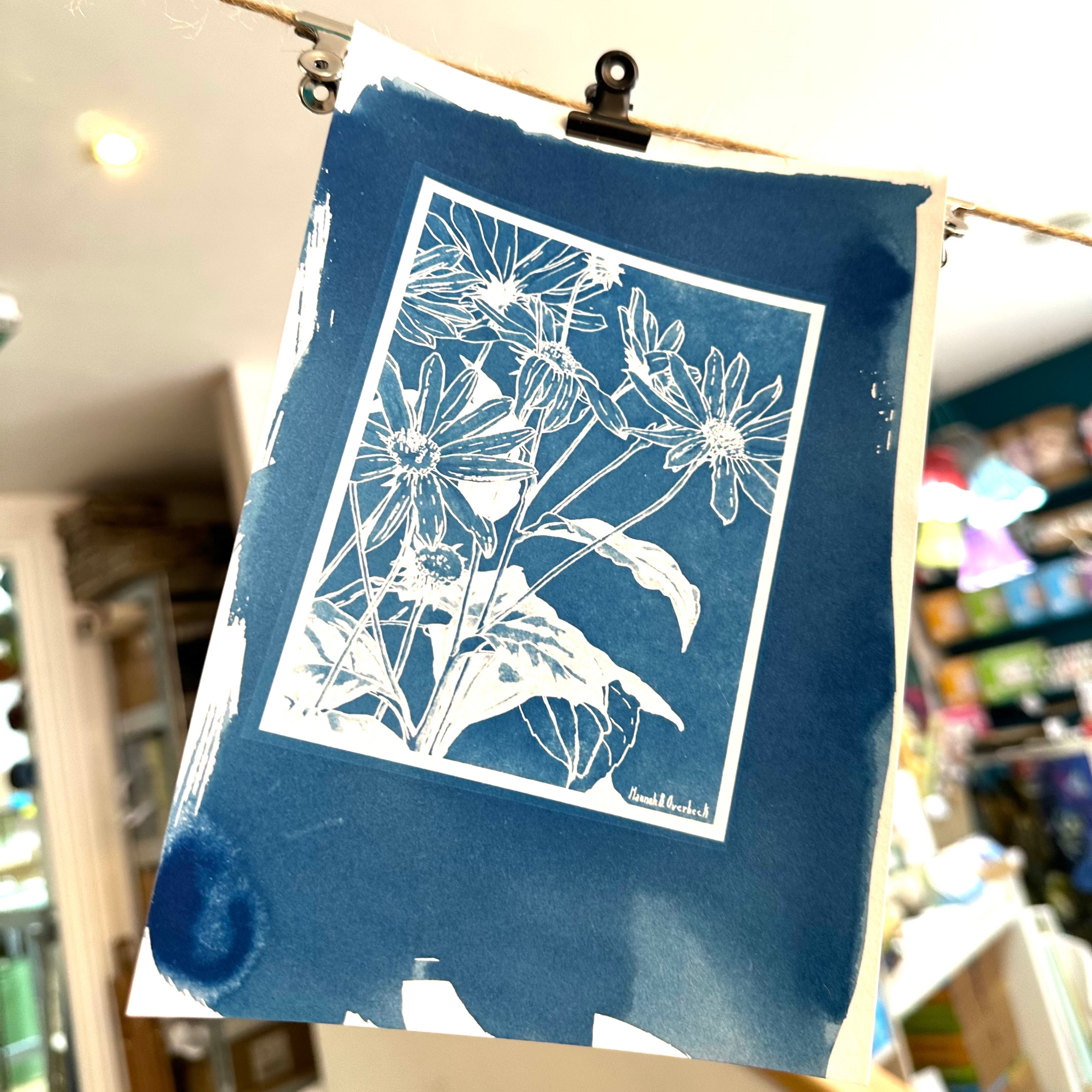 Blue floral print hanging on a wire in a store setting