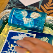 Blue soap bar with text on a tray, hand reaching towards it