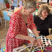 Two women standing close to each other in a room with colorful decor.