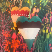 Colorful wooden pencil-shaped object held by a hand against a vibrant, abstract background.