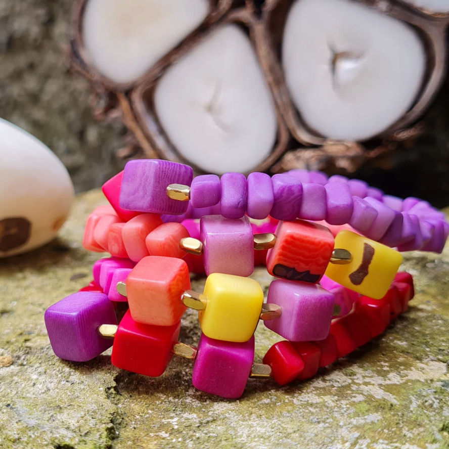 Colorful beaded bracelet with square beads on a textured surface