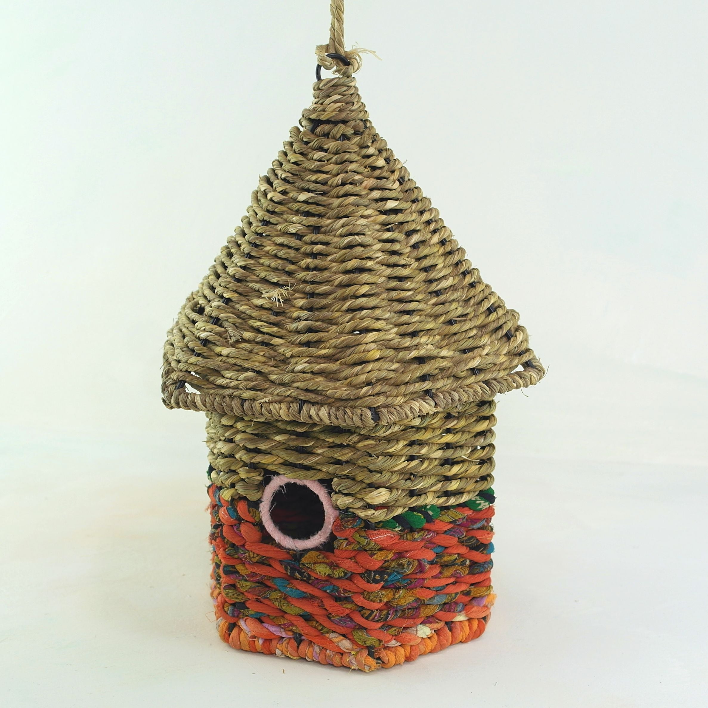 Bird nester in grass and sari fabric, house shape