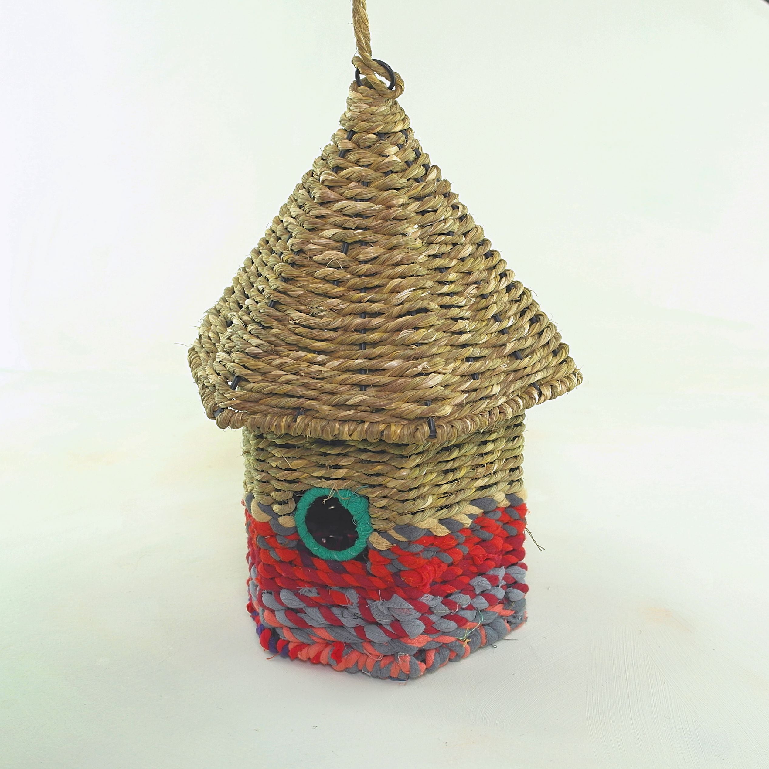 Bird nester in grass and sari fabric, house shape