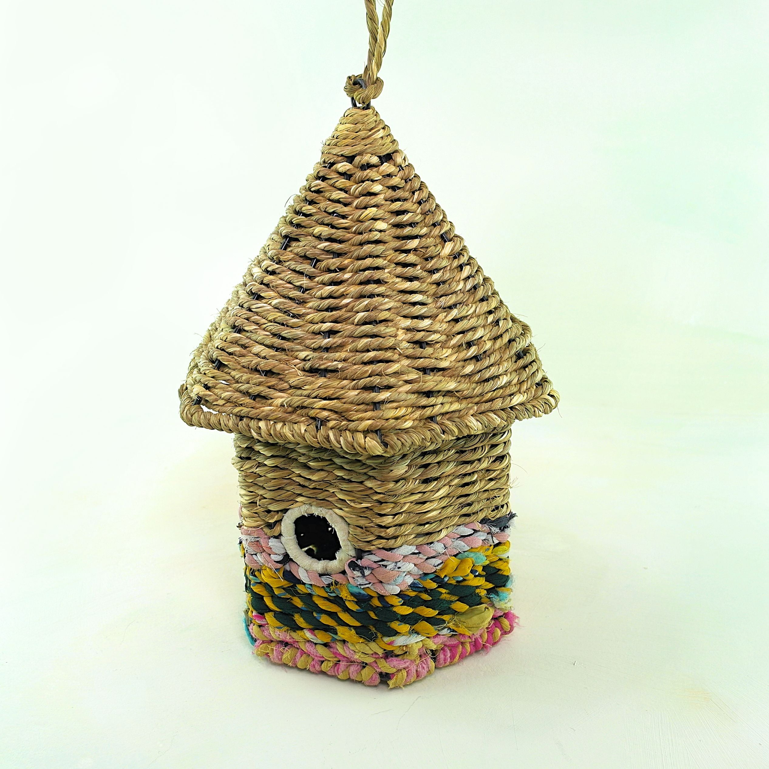 Bird nester in grass and sari fabric, house shape