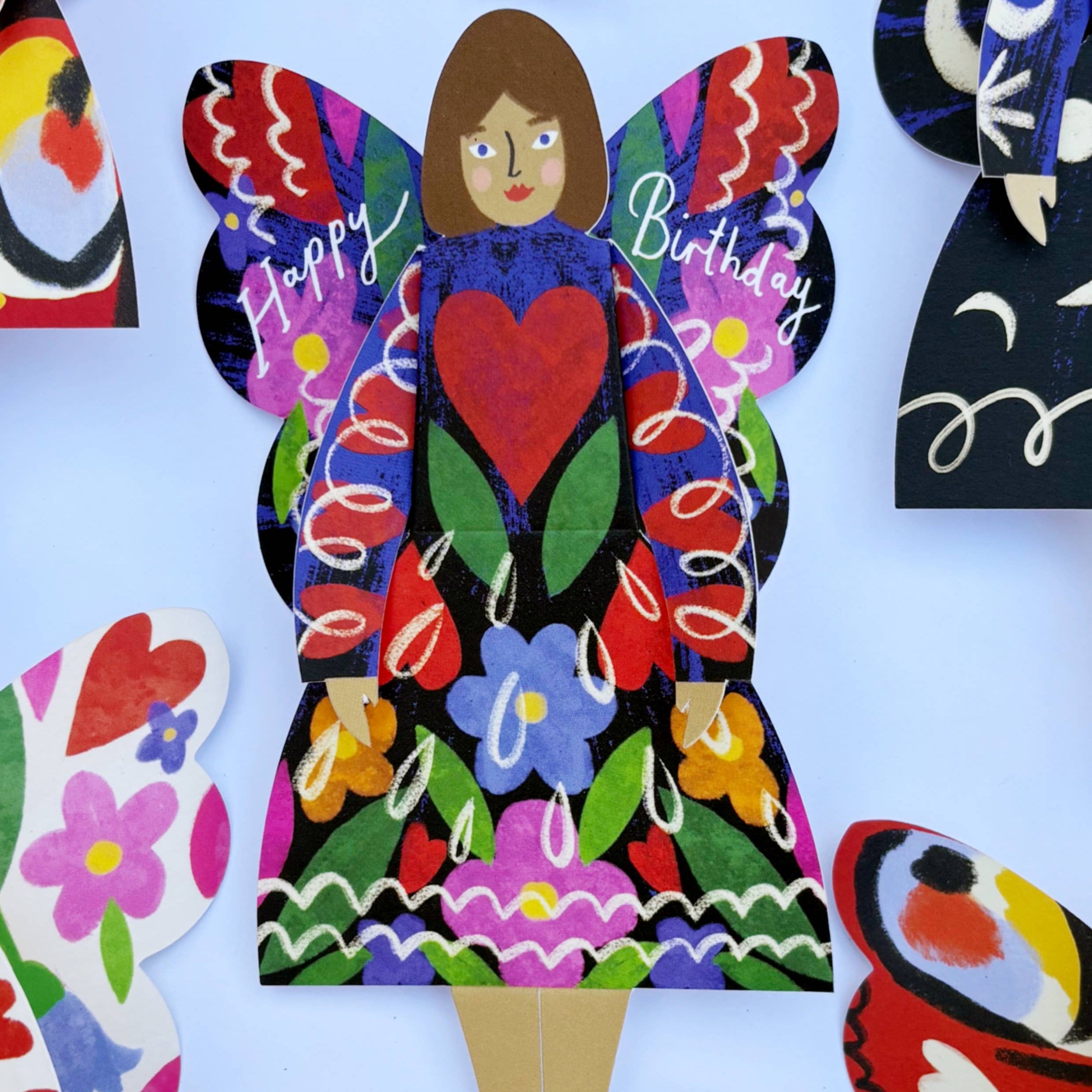 Colorful paper doll with butterfly wings and 'Happy Birthday' text on a white background, featuring Kitty Kenda branding.