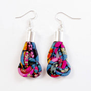 A pair of handmade teardrop dangle earrings made from colorful scrapbook fabric with silver fishhook wires, displayed on a clean white background.