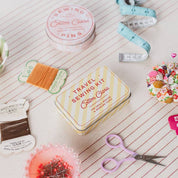 Travel sewing kit with supplies on a notebook page