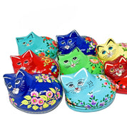 Colorful cat-shaped tin boxes with floral designs on a white background