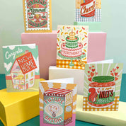 Collection of colorful greeting cards on a teal surface with a light green background