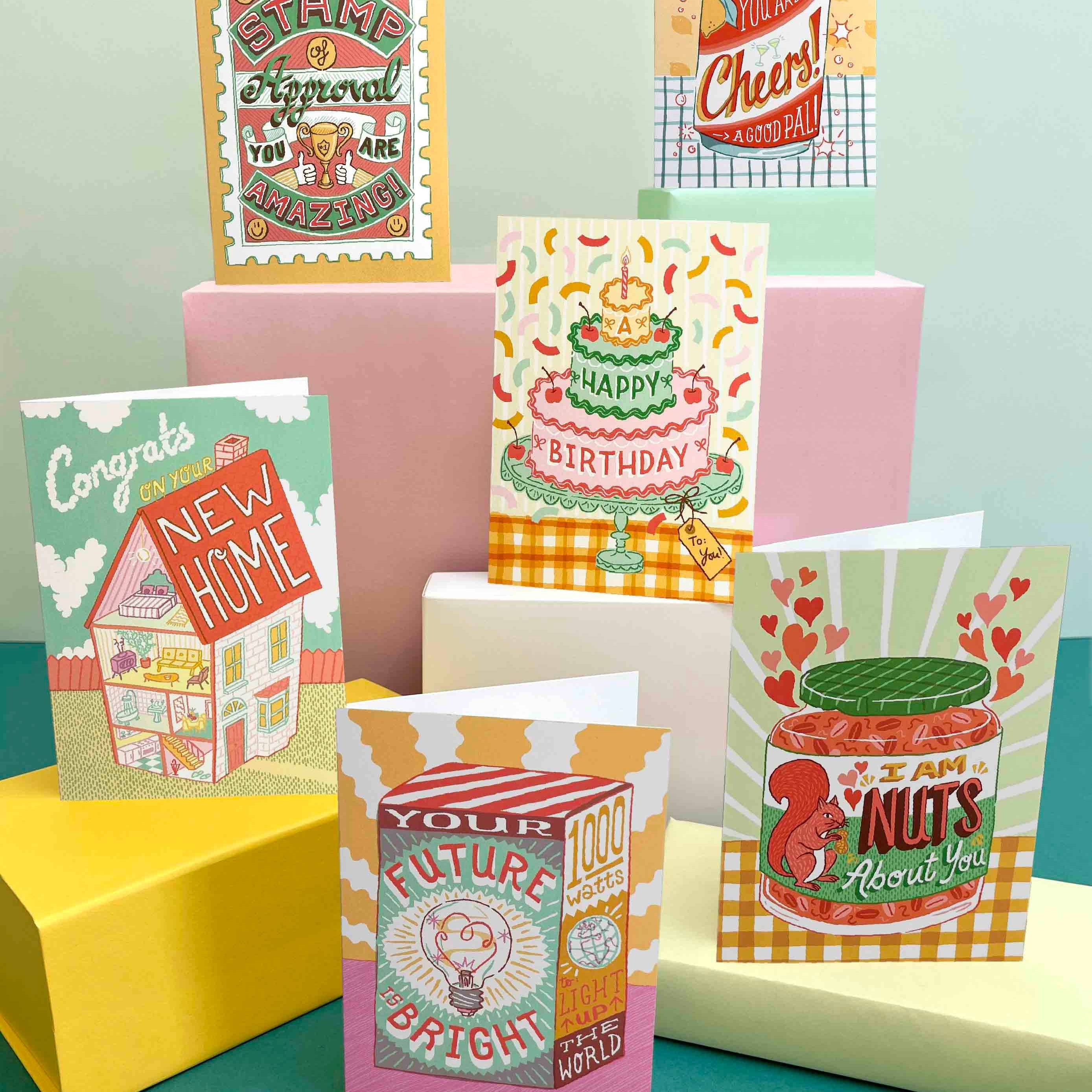 Collection of colorful greeting cards on a teal surface with a light green background