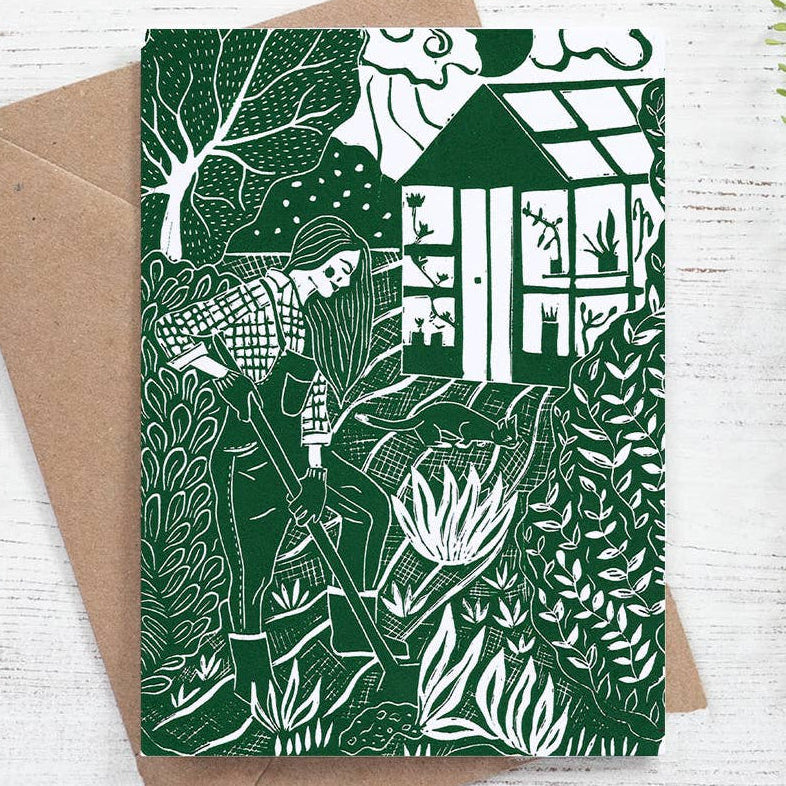 Greeting card with nature-themed design and brown envelope on a white wooden surface