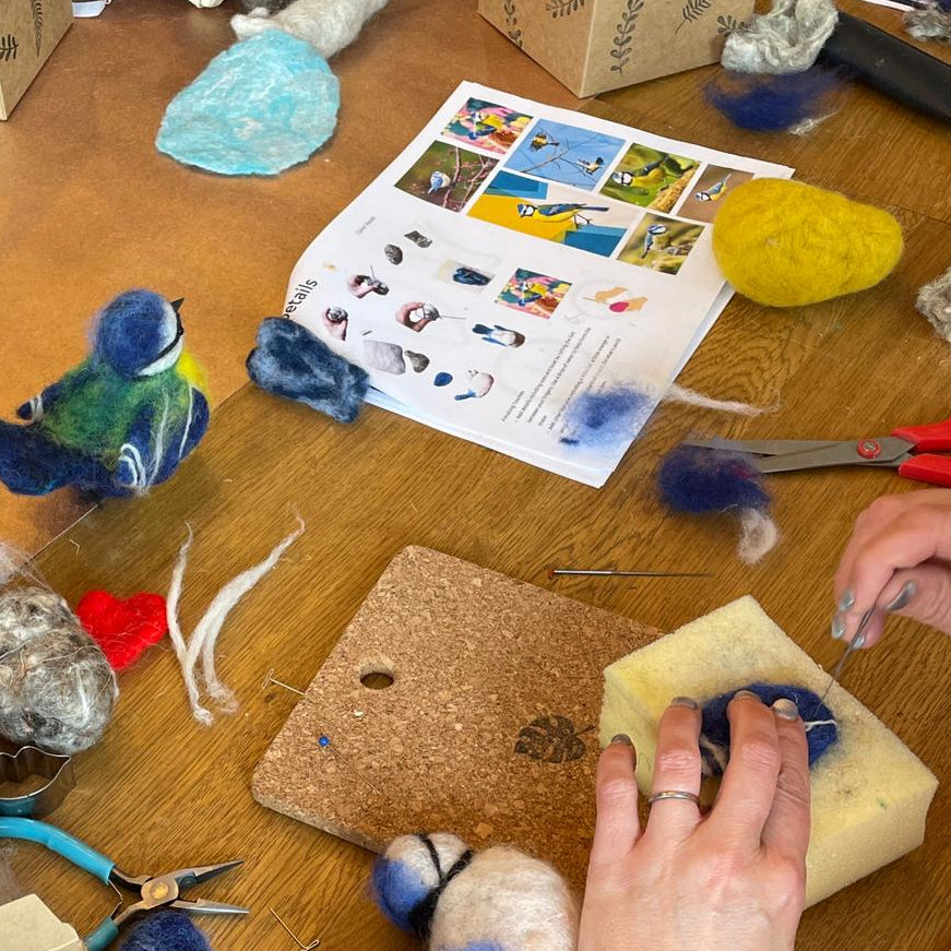 Crafting activity on a wooden table with various materials and tools.