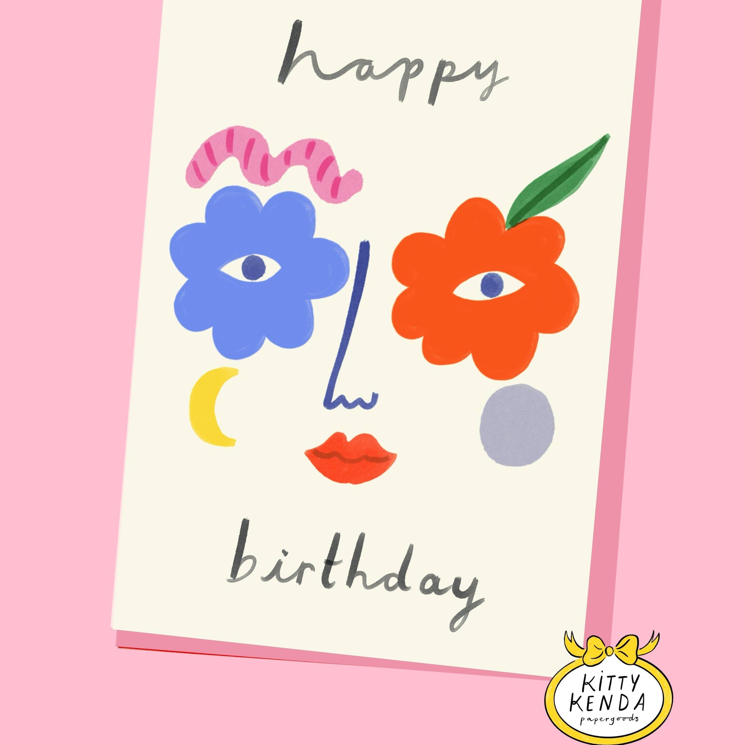 Birthday card with colorful face design and 'Happy Birthday' text on a pink background