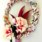 Colorful braided wreath with flowers on a white background