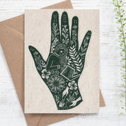 Greeting card with green hand illustration on beige paper with brown envelope
