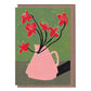 A greeting card with a linocut print of red flowers in a pink vase on a green background, accompanied by a kraft envelope.