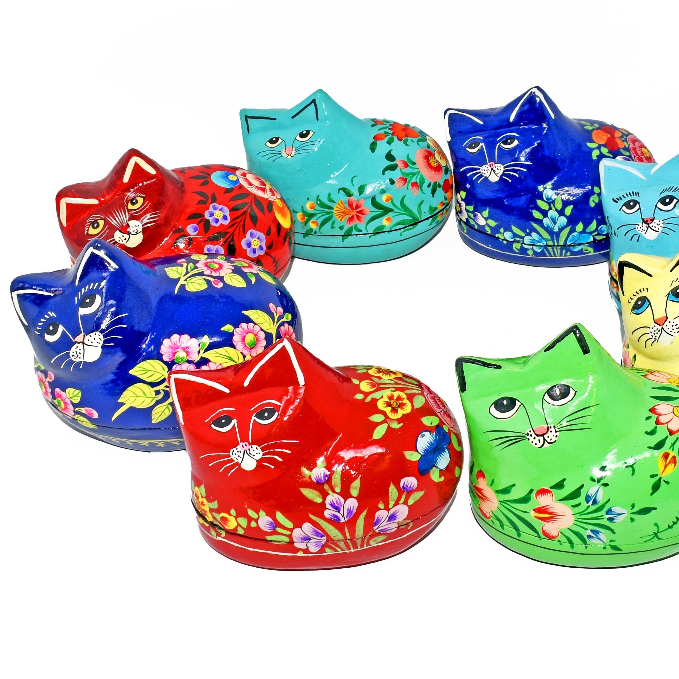 Set of colorful cat-shaped tins with floral designs on a white background