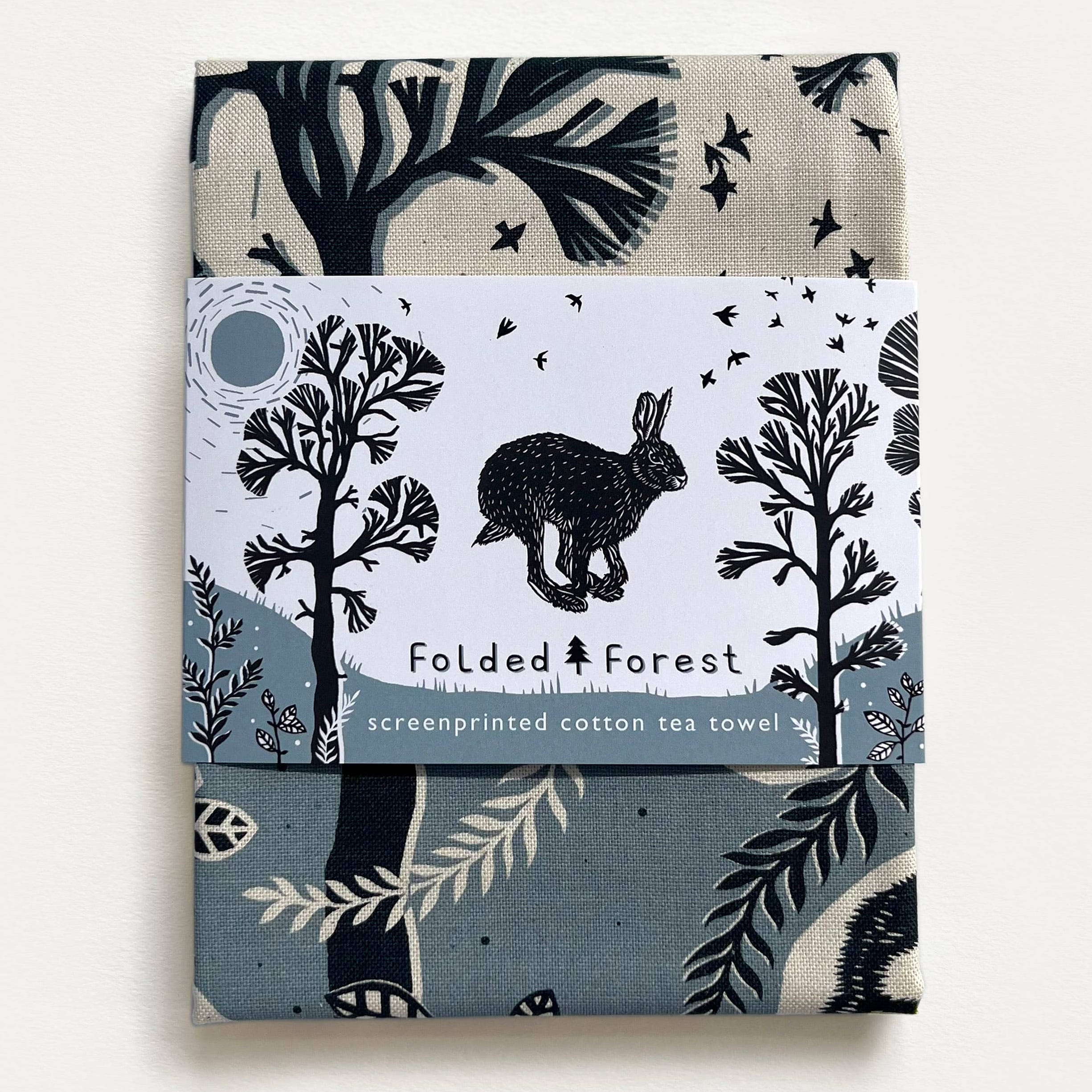Cotton tea towel with forest design and rabbit illustration on a white background