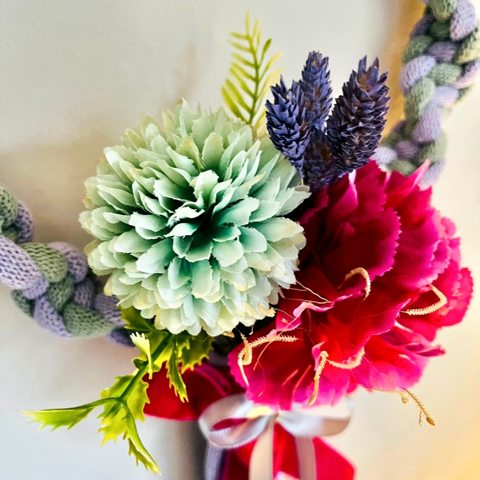 Bouquet of flowers with green, red, and purple elements on a blurred background