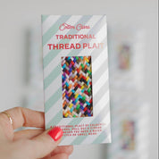 Cotton Clara Traditional Thread Plait packaging held by a hand with red nail polish.