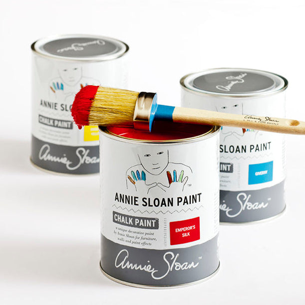 Three cans of Annie Sloan Chalk Paint with a brush on a white background
