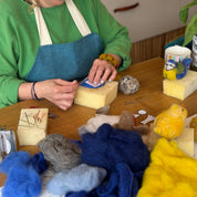 Woman working with yarn and craft materials on a table