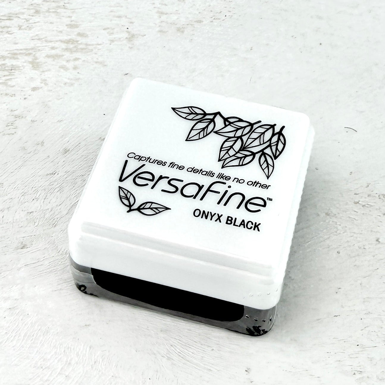 Versafine Onyx Black ink pad on a light gray background