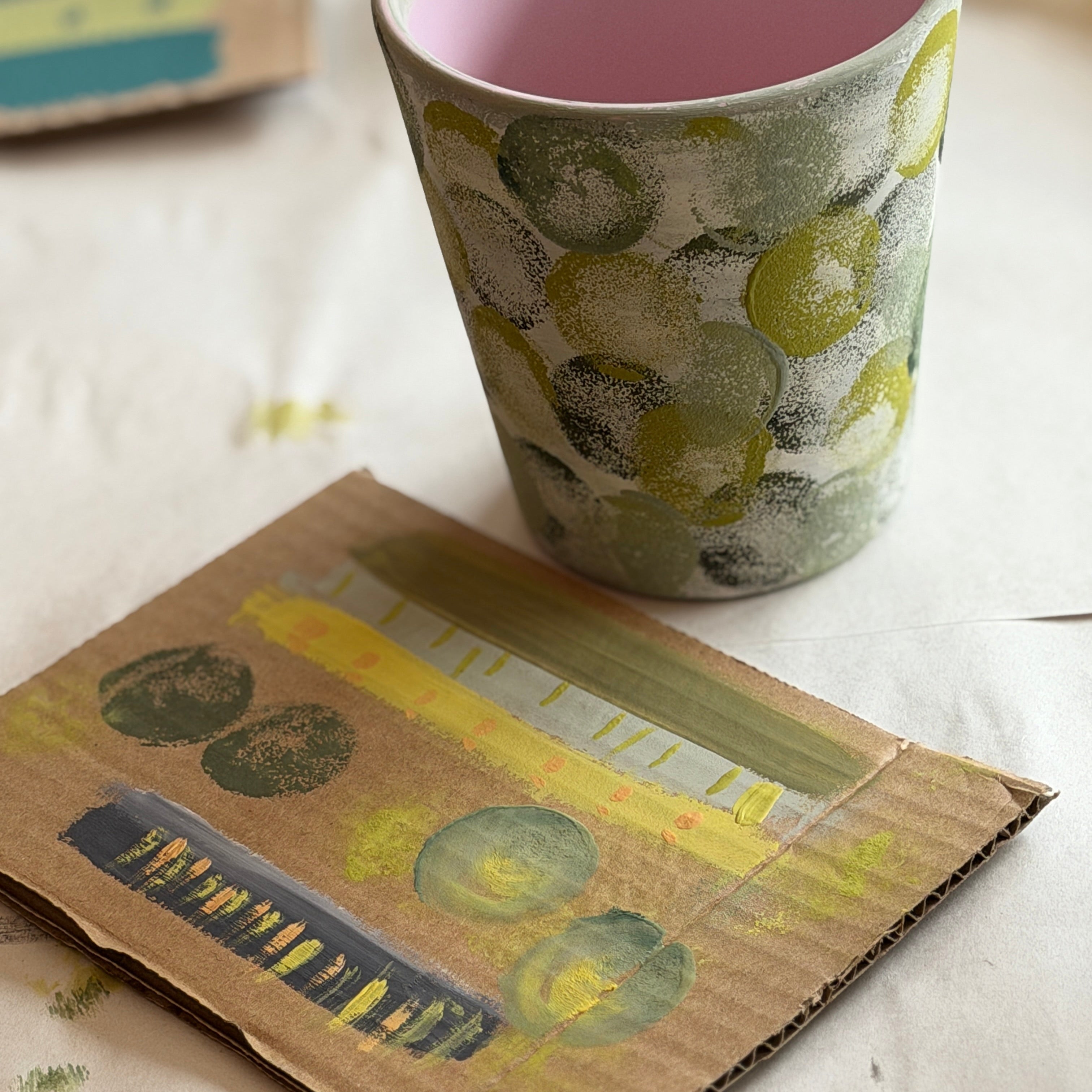 Cup with pink interior on a surface next to a patterned book