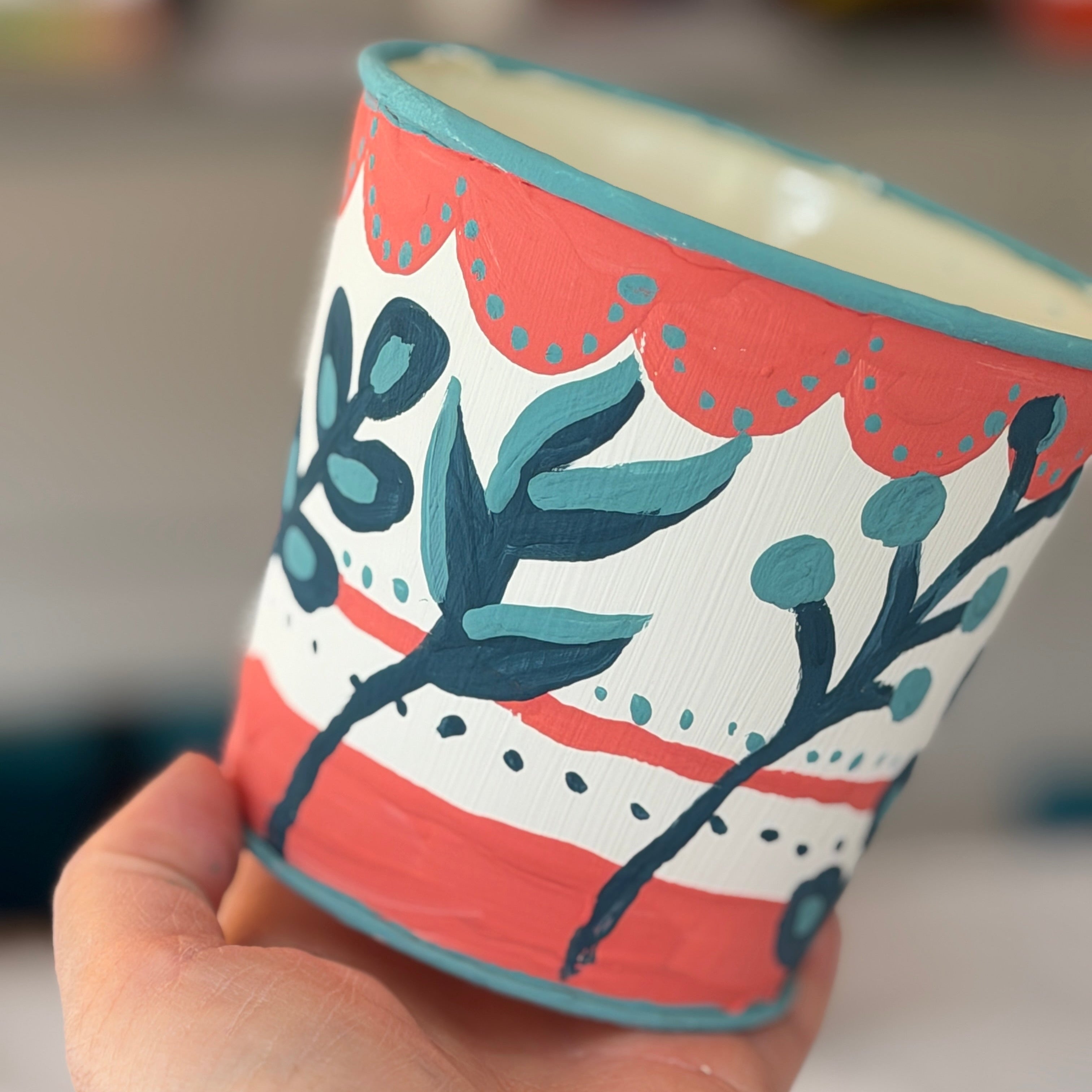 Hand holding a decorative candle with floral patterns