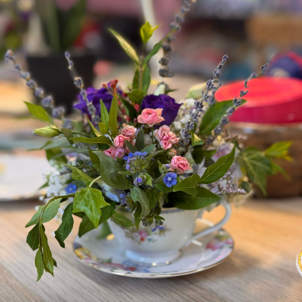 Small floral arrangement on a saucer with a blurred background