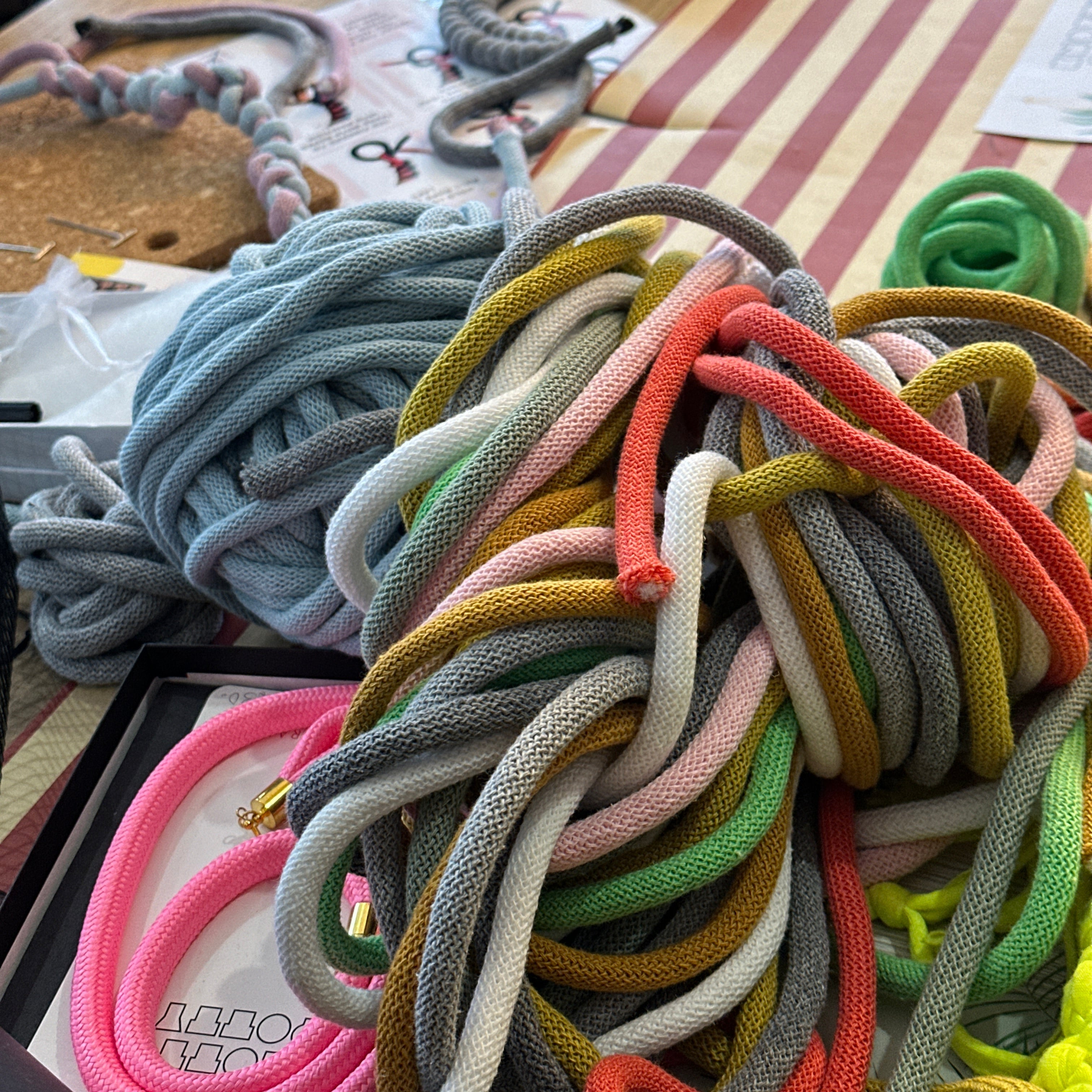 Colorful braided cords on a pegboard with various tools in the background