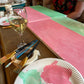 Art supplies including paintbrushes and a paper plate with paint on a wooden surface.