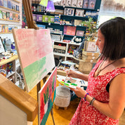 Woman in a floral dress looking at art prints in a store