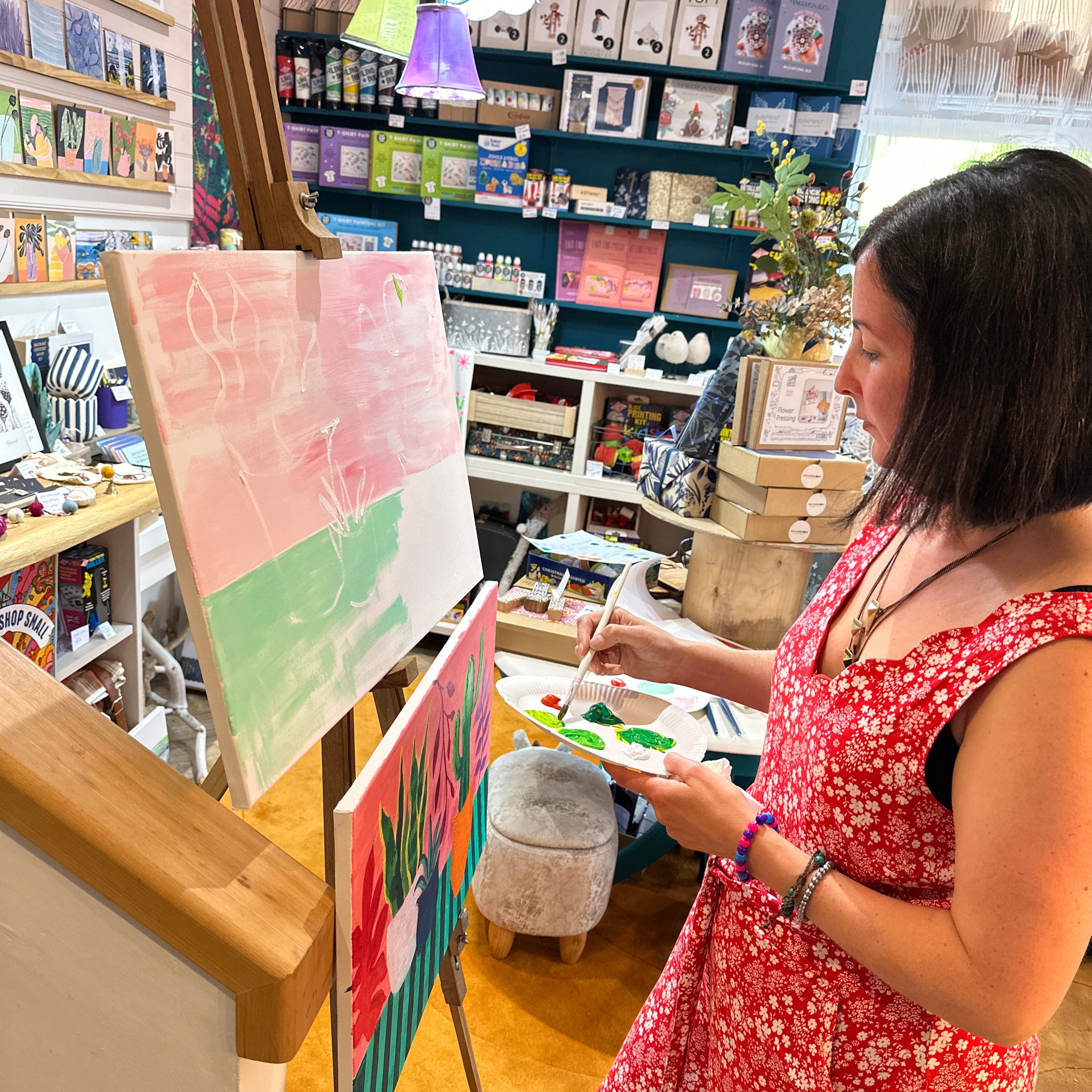 Woman in a floral dress looking at art prints in a store