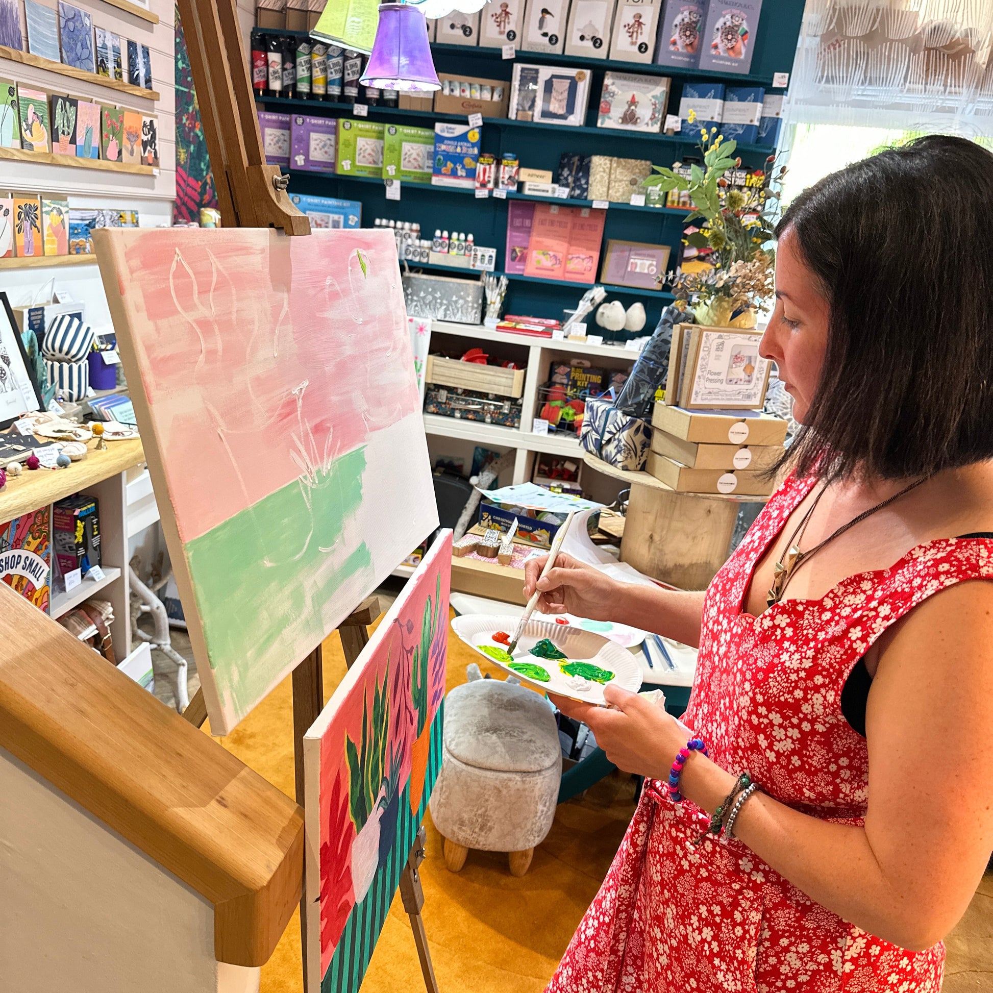Woman in a floral dress looking at art prints in a store