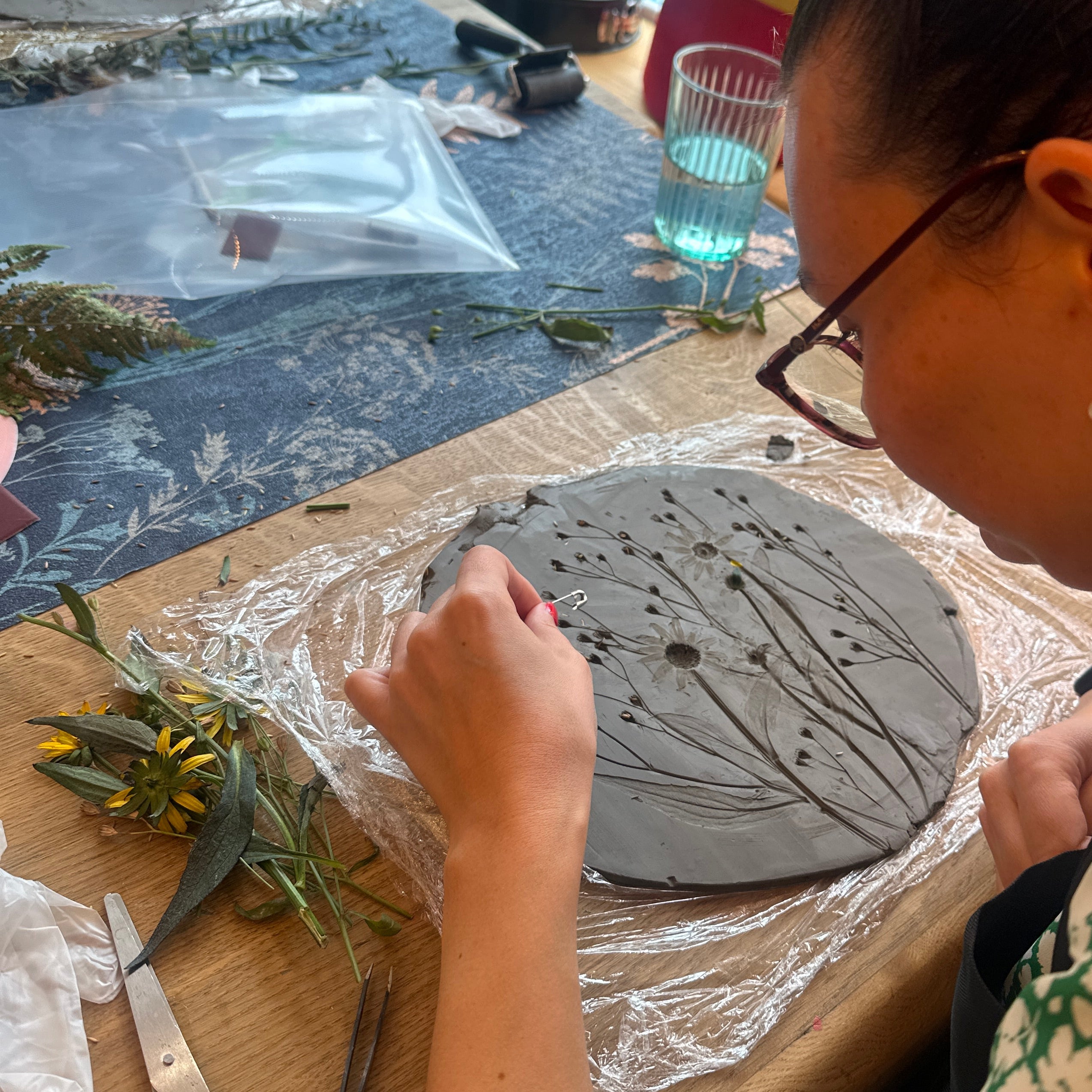 Person working on a craft project with materials on a table