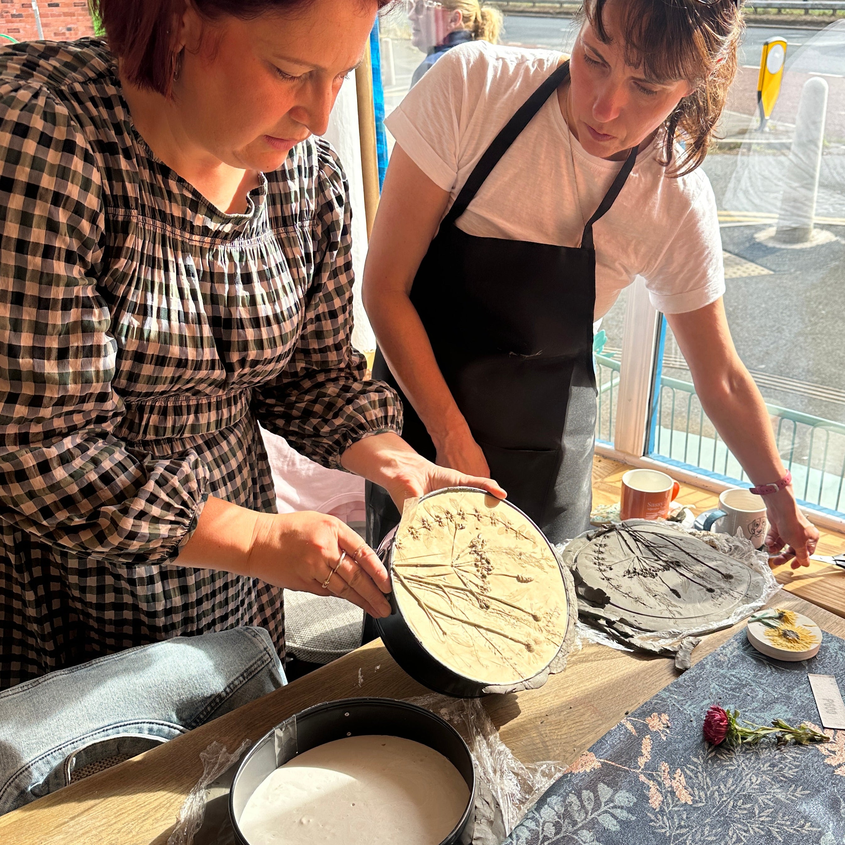 Two women working with clay in a pottery studio.