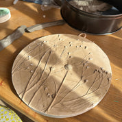 Ceramic lid with floral design on a wooden surface