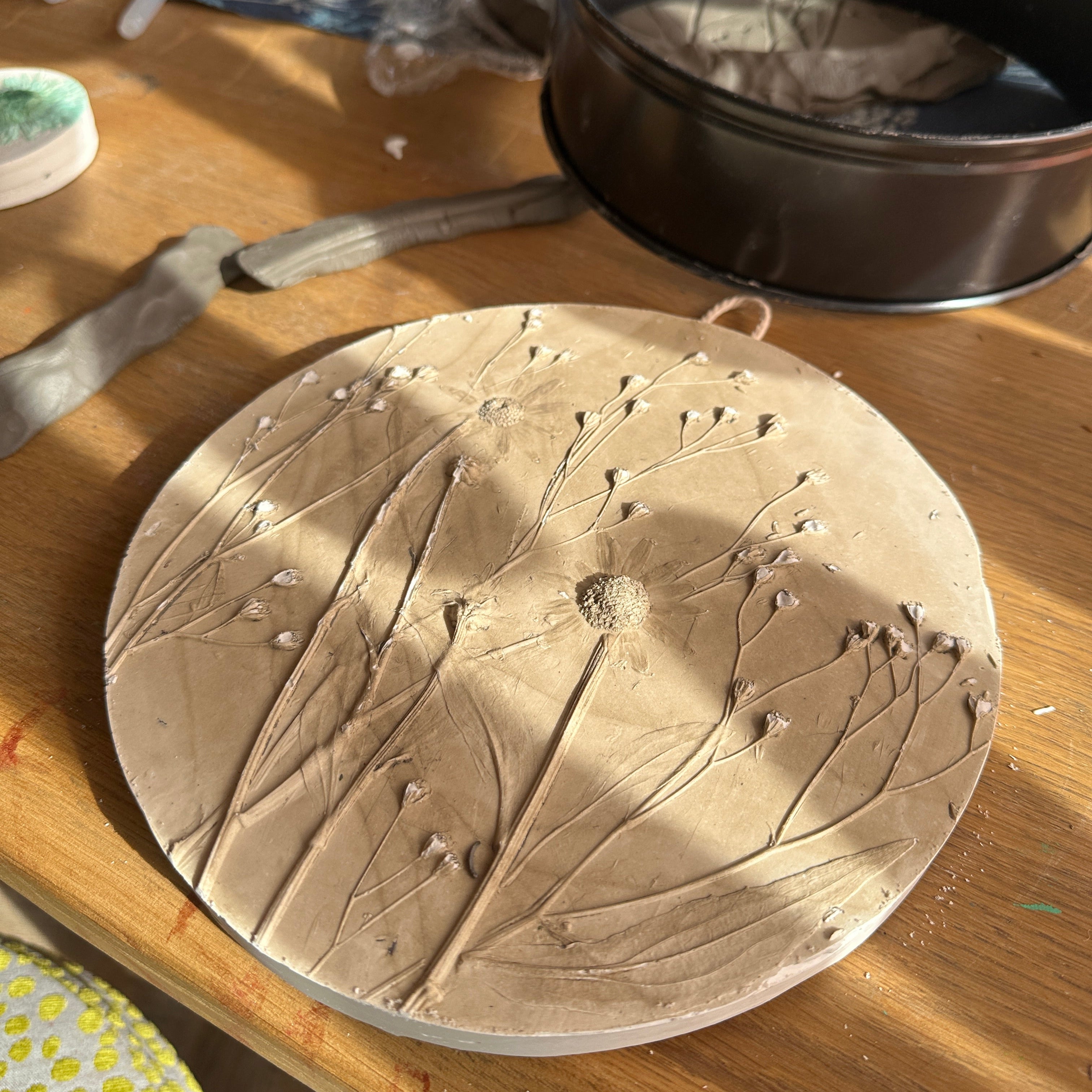 Ceramic lid with floral design on a wooden surface