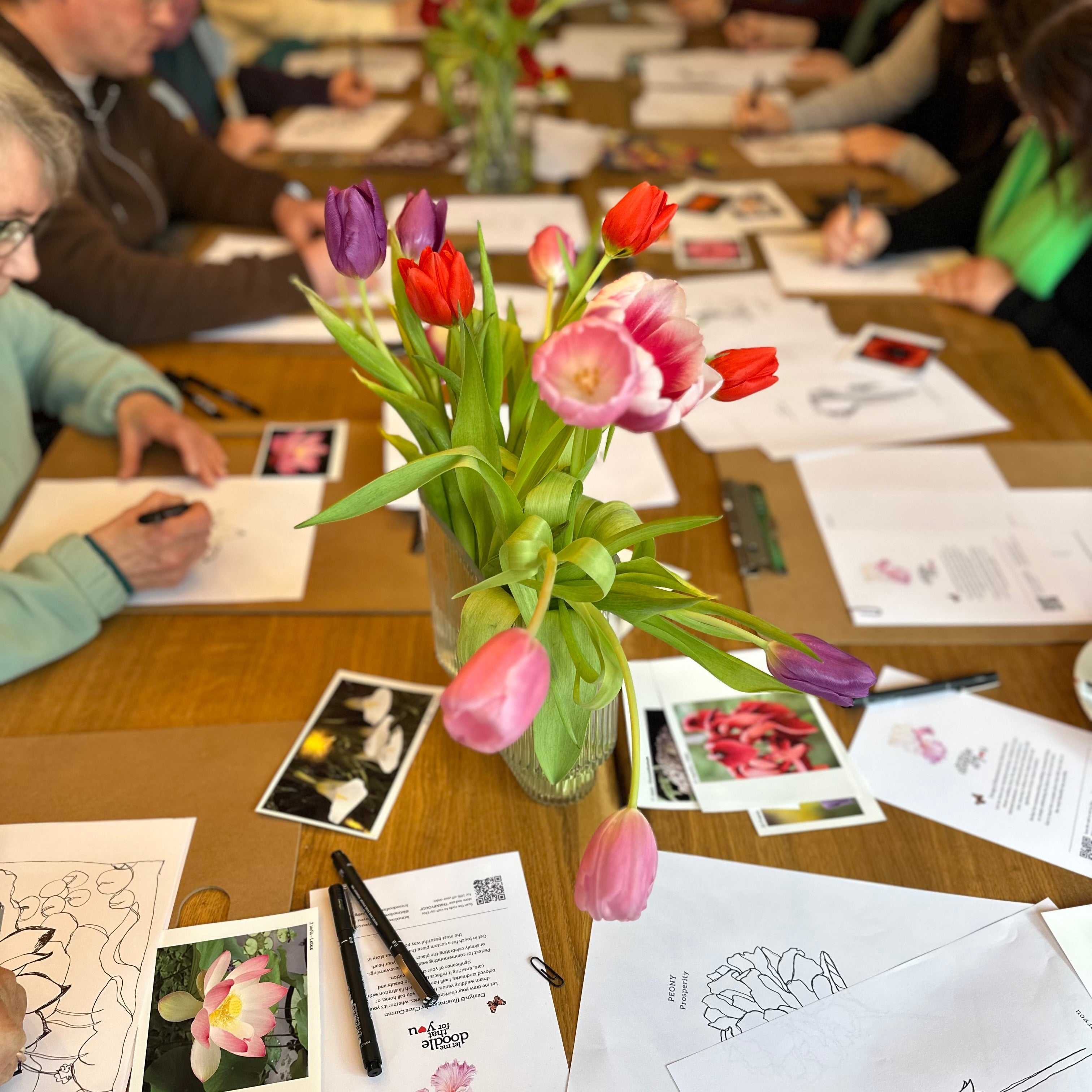 Table with floral arrangements and coloring books in a classroom setting