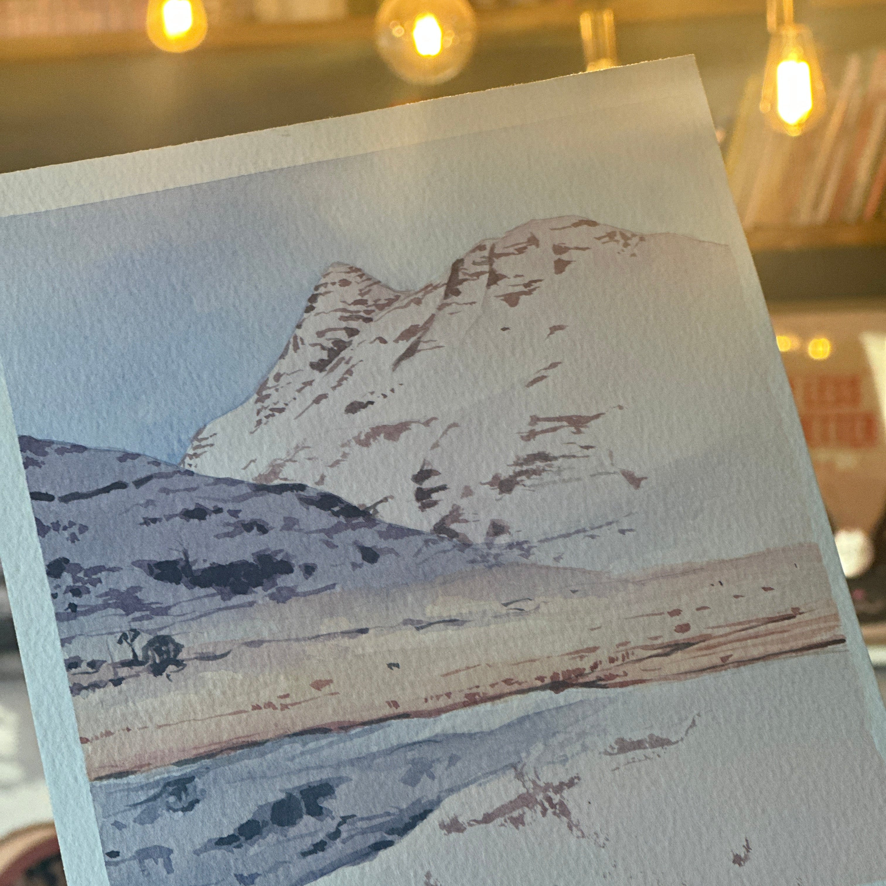 Close-up of a textured fabric swatch held by a hand with a blurred indoor background.