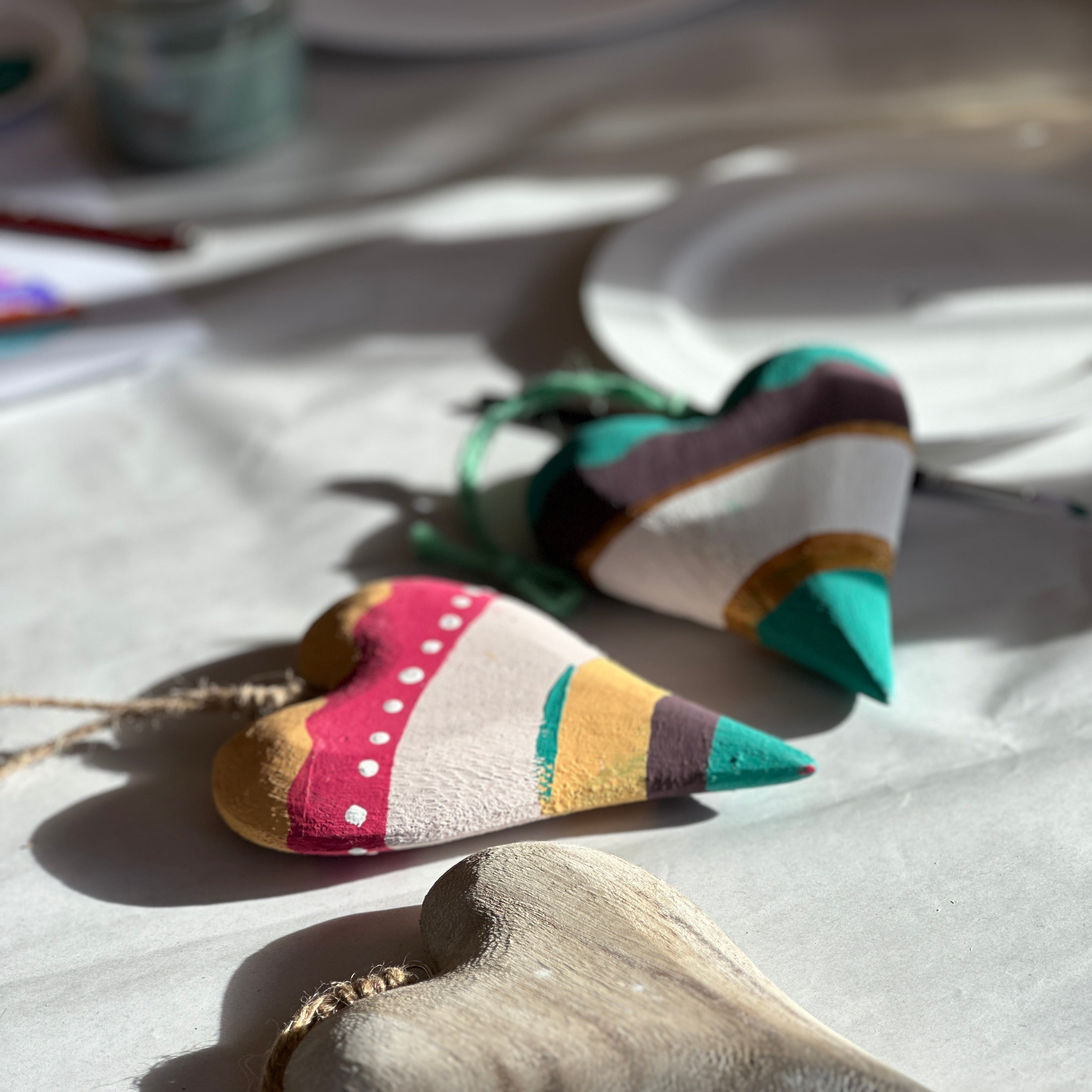 Colorful fabric heart-shaped decorations on a white surface