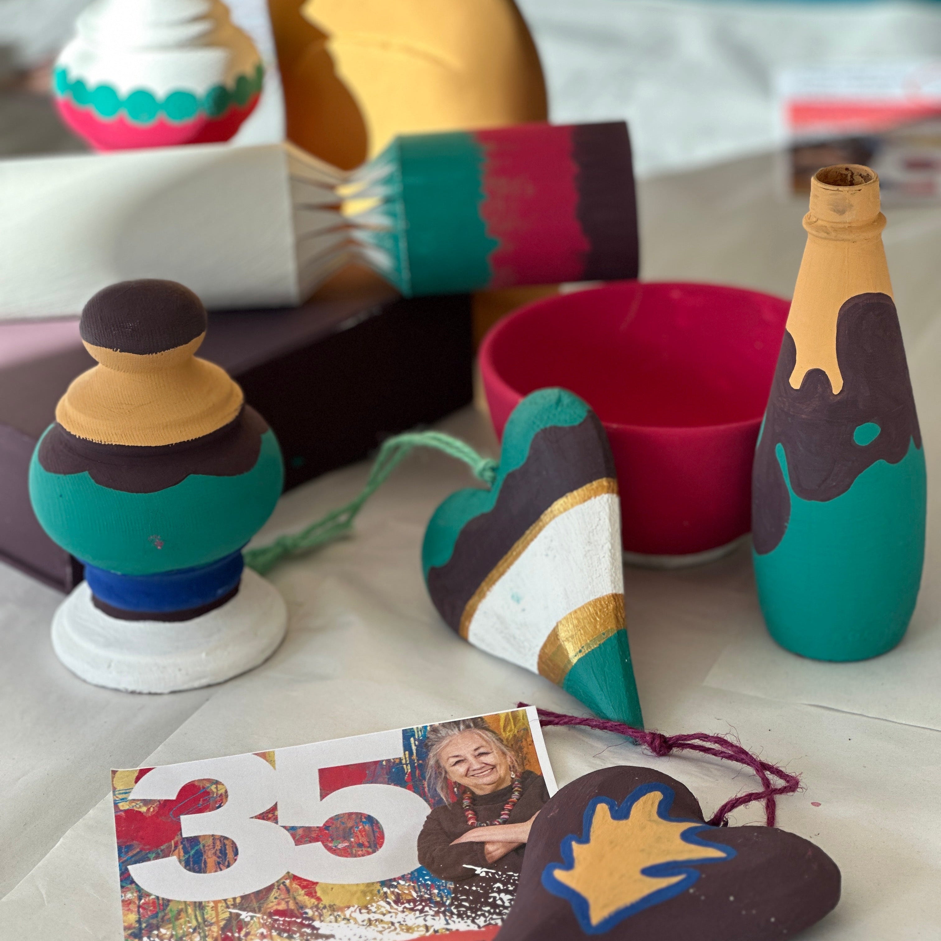Decorative bottles and heart-shaped ornaments on a table with a colorful card.