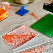 Close-up of a table with bubble wrap, colorful paper, and a blue object.