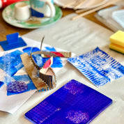 Blue textured art piece on a table with tools and materials