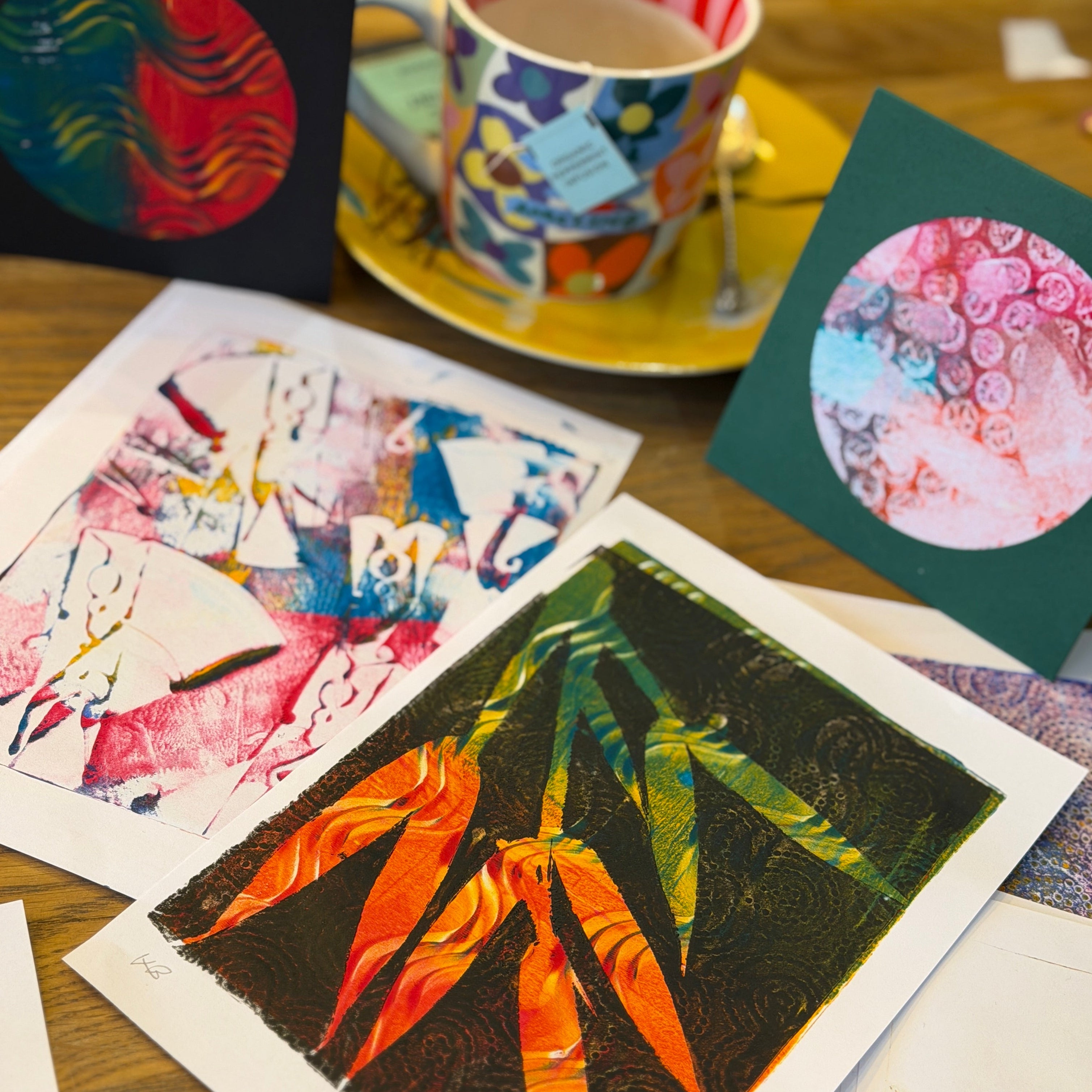 Colorful greeting cards and a cup of tea on a wooden table