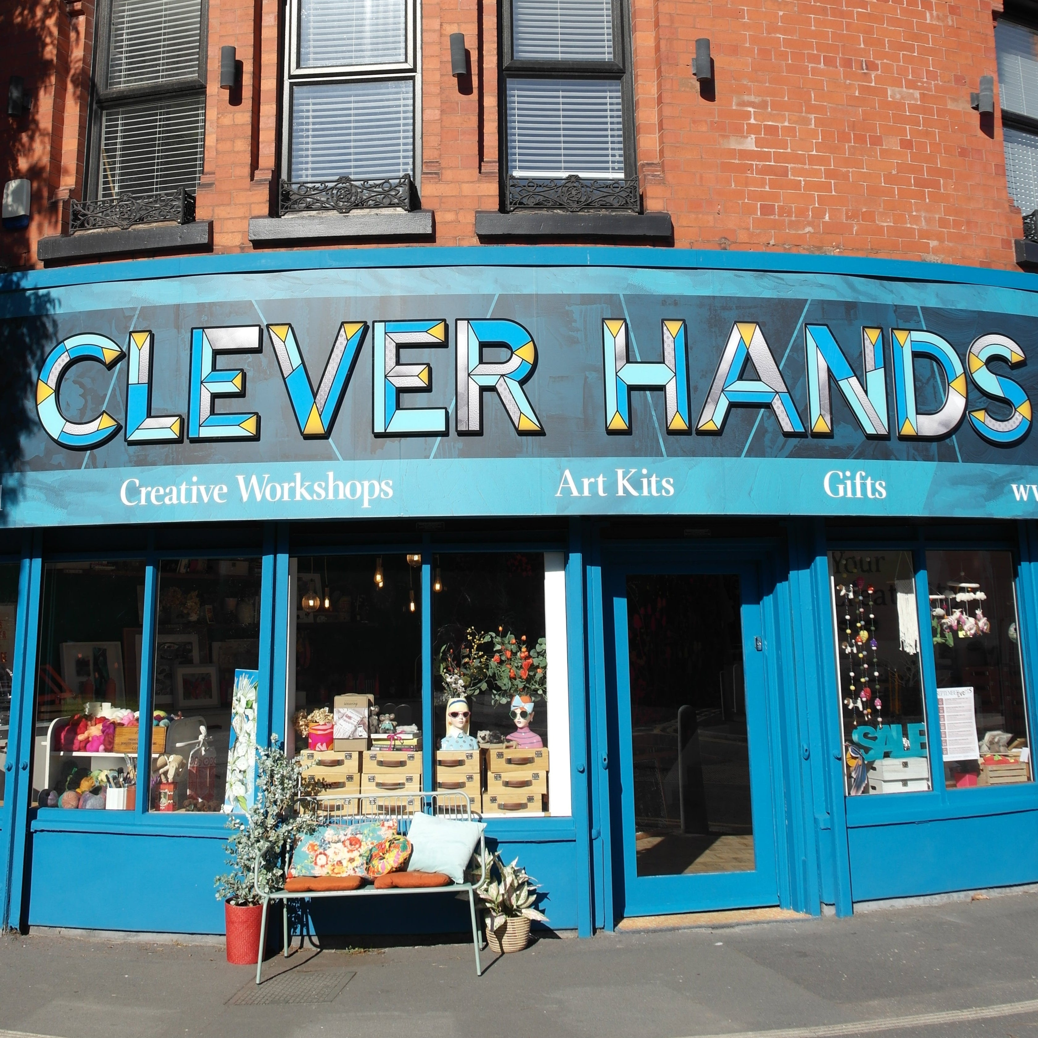 Blue building facade with 'Clever Hands' branding on a clear day