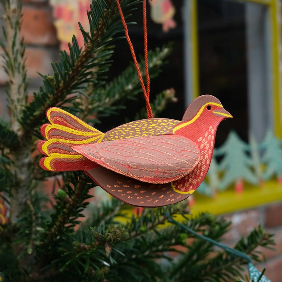 Decorative bird ornament hanging on a Christmas tree