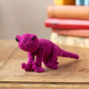 Purple dinosaur toy on a wooden table with a blurred background